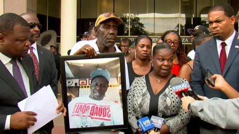 The family of Jawan Dallas hold up a photo of him during a press conference on Thursday, July 6.